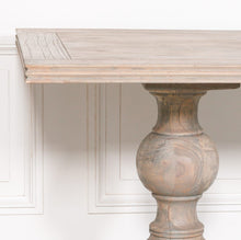 Load image into Gallery viewer, A beautifully handcrafted 240cm dining table made from solid mango wood, featuring a light rustic finish and two detailed hand-carved columned pedestal legs.