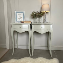 Load image into Gallery viewer, Two matching side tables with decorative items against a neutral wall.