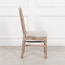 Load image into Gallery viewer, Elegant and timeless, this Wooden Louis Dining Chair features a carved birch frame with a subtle wood wash, a rattan square back, and a linen-upholstered seat, and is conveniently stackable.