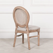 Load image into Gallery viewer, A classic Louis-style dining chair carved from birch wood with a light washed finish, featuring a woven balloon back, linen upholstered seat, and stackable design for practical elegance.