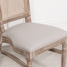 Load image into Gallery viewer, Elegant and timeless, this Wooden Louis Dining Chair features a carved birch frame with a subtle wood wash, a rattan square back, and a linen-upholstered seat, and is conveniently stackable.