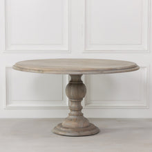 Load image into Gallery viewer, A beautifully handcrafted 147cm round dining table in a rustic finish, featuring a solid wood top and an elegant hand-carved columned pedestal base.