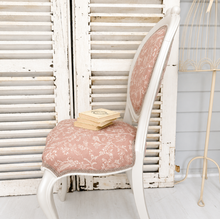 Load image into Gallery viewer, Vintage-style chair with pink floral cushion in front of white wooden shutters.