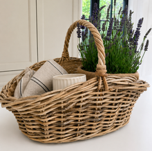 Load image into Gallery viewer, Wicker basket with a towel, container, and lavender plant on a light surface.
